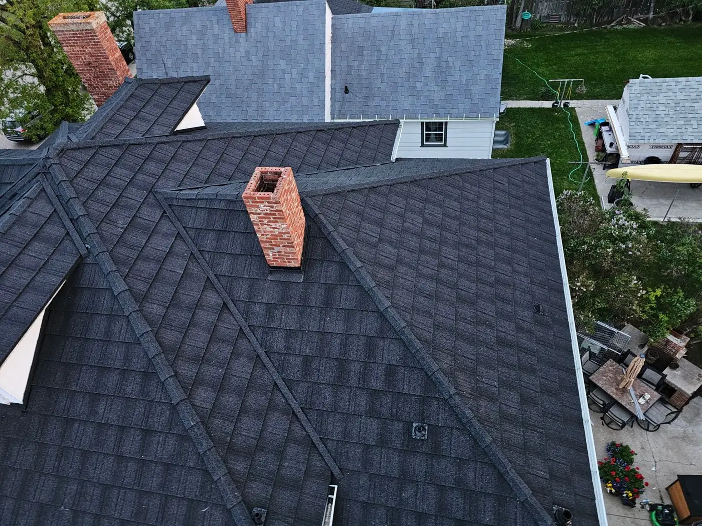 New Malarkey-style architectural shingles on a home with a brick chimney