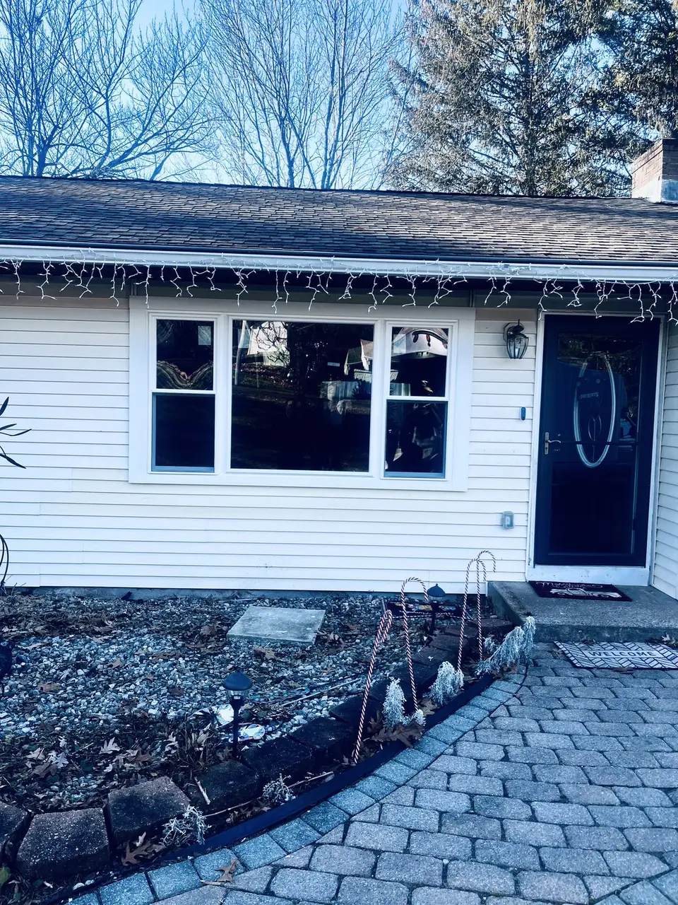 White ranch home with a new black entry door