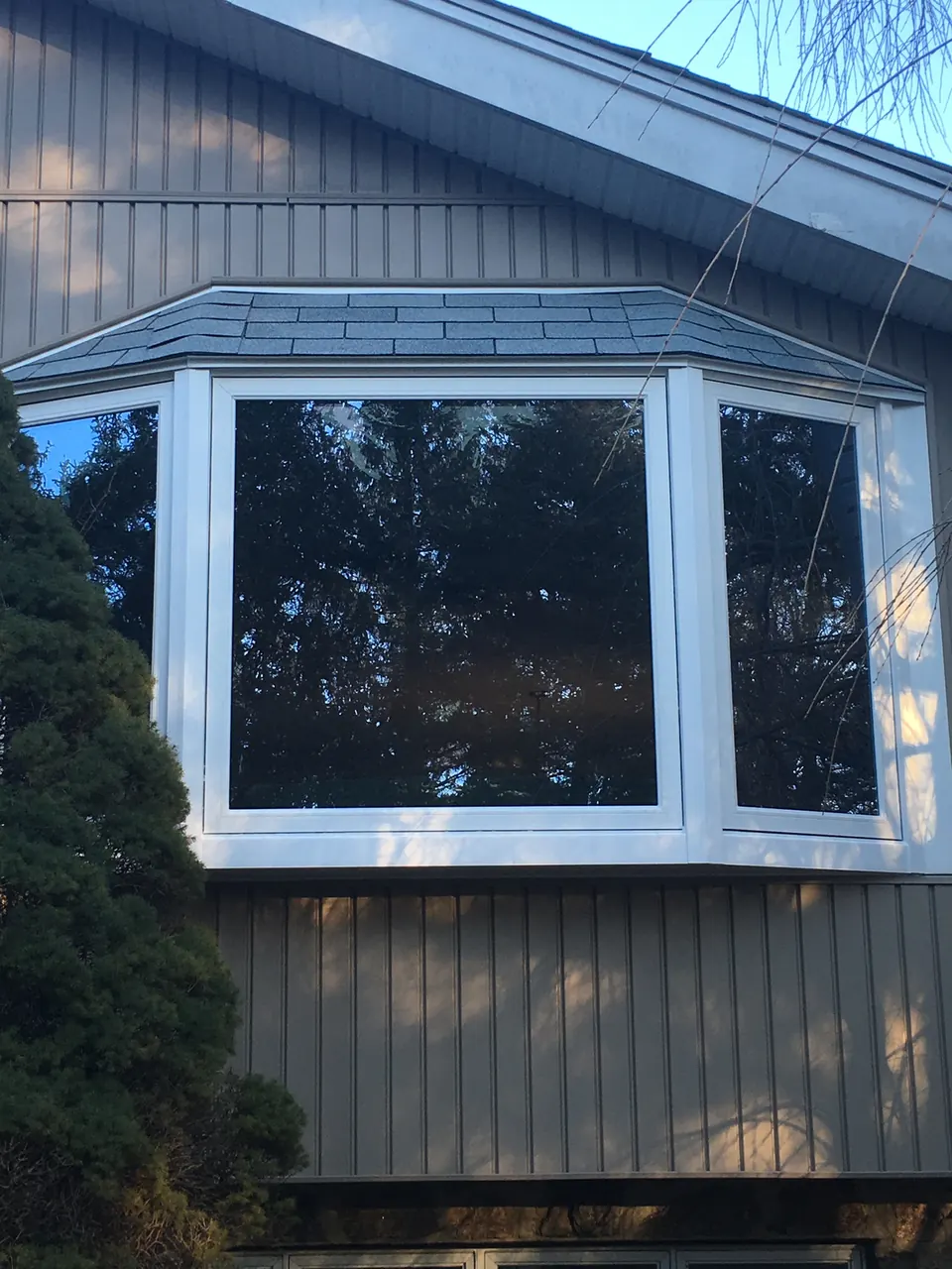 New white bay window on a gray-sided home